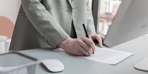 Mann an Schreibtisch, der ein Dokument unterschreibt - Artikelbild von Lexware