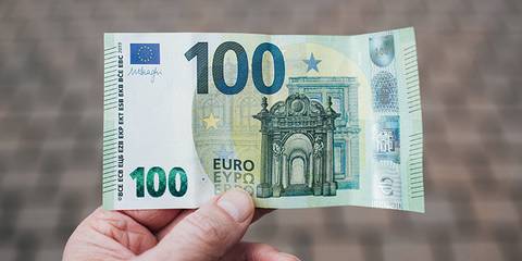 Person hält einen 100 Euro-Schein