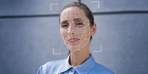 Frau mit einem digitalen Gesichtserkennungsmuster im Gesicht.