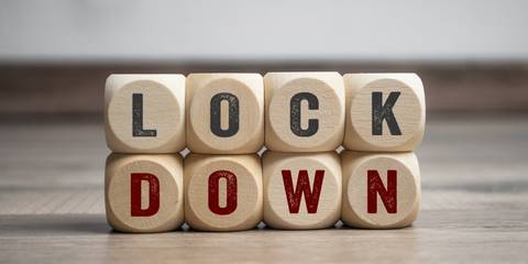 Zwei mal vier Würfel in zwei Reihen gestapelt bilden gemeinsam das Wort "Lockdown" 
