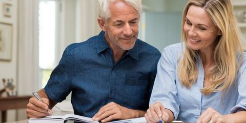 Älteres Ehepaar sieht Finanzen am Tisch durch
