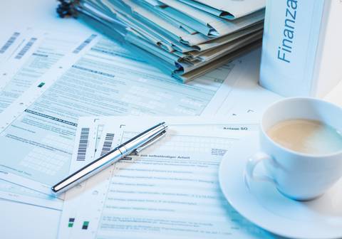 Unterlagen zur Steuererklärung mit einer Tasse Kaffee
