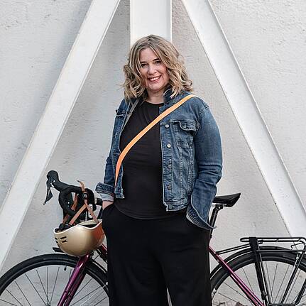 Bild von Lexware: Frau in Jeansjacke, die vor ihrem City Bike steht
