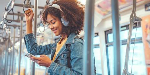 Junge schwarze Frau hört Musik in der Straßenbahn