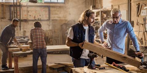 Vier Männer arbeiten in einer Werkstatt