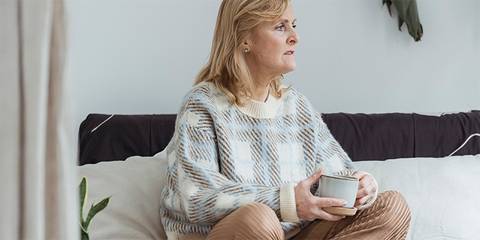 Frau mit Kaffee auf einem Sofa sitzend Artikelbild Firmennamen finden