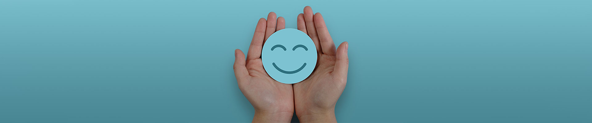 Hände halten ein rundes Stück Papier mit einem Smile drauf