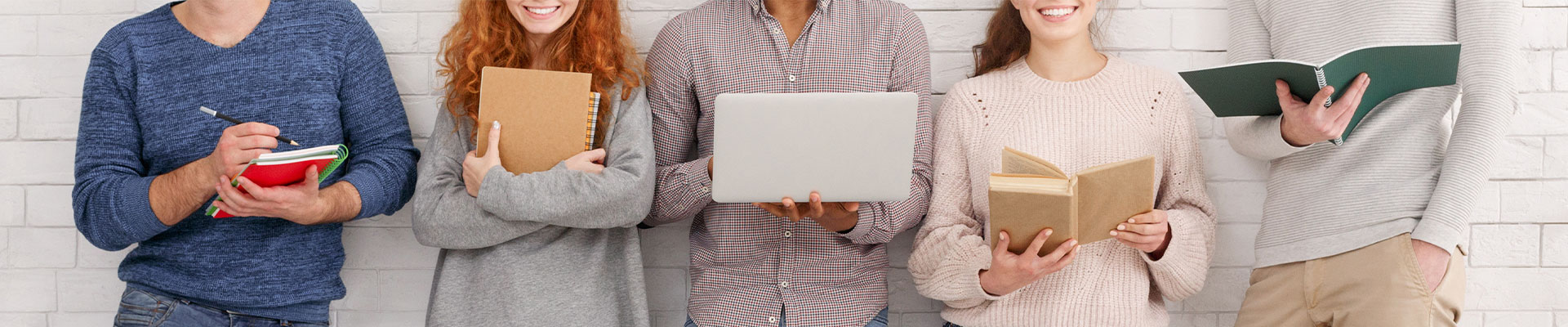 Fünf Personen stehen nebeneinander vor einer Wand und halten jeweils Laptop oder Notizbuch in der Hand