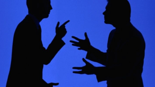 Zwei Personenschatten diskutieren vor blauem Hintergrund